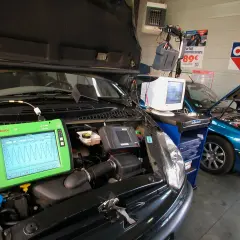 Diagnostic automobile chez Opel France. Un écran Bosch affiche des courbes, une voiture bleue est en réparation.