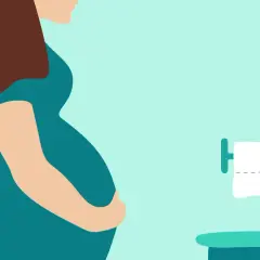 Femme enceinte tenant son ventre, près de toilettes avec papier. Une situation courante pour une femme enceinte qui cherche un laxatif doux.