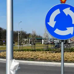 Znak informuje, kto ma pierwszeństwo na rondzie. Trzy białe strzałki na niebieskim tle wskazują kierunek ruchu i sugerują, że pojazdy na rondzie mają pierwszeństwo.