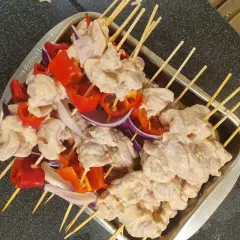 Shish tawook-spett på spett med kyckling, paprika och lök, redo att grillas.