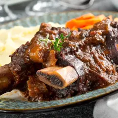 Plat de côte au four, tendre et savoureux, servi avec purée et carottes. Le temps de cuisson est parfait pour cette viande.