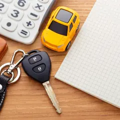 Kluczyki do auta, kalkulator i notatnik – wszystko gotowe do rejestracji samochodu online.