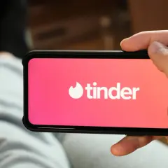 Dłoń trzyma smartfon z logo Tindera. Szukasz alternatywy dla Tindera? Może warto spróbować czegoś nowego.