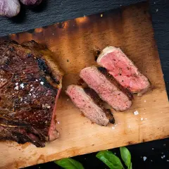 Perfekt gegrilltes T-Bone-Steak, aufgeschnitten, um die ideale Kerntemperatur und saftige Textur zu zeigen.