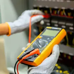 Elektryk z multimetrem wykonuje pomiary elektryczne. Sprawdź nasz cennik usług.