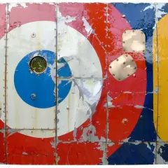 Panneau métallique style pop art, aux couleurs vives et écaillées, rappelant les cocardes d'avions et des chiffres.