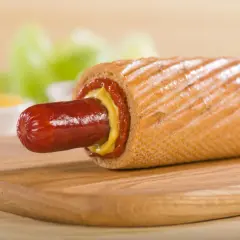 Pyszny hot dog francuski z musztardą i ketchupem na desce.