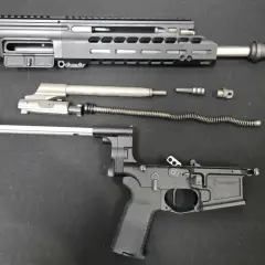 Rozłożony karabinek AR-15: górna i dolna część komory zamkowej, lufa, suwadło, sprężyna powrotna i inne części.
