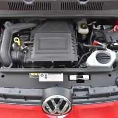 Silnik 1.0 TSI w czerwonym Volkswagenie. Widoczny jest układ dolotowy, akumulator i płyny eksploatacyjne.