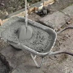 Taczka z betonem i łopatą, gotowa do wylania zbrojenia ławy fundamentowej 40x60.