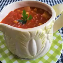 Pikantny sos chiński z kawałkami warzyw i kukurydzy, podany w ozdobnym naczyniu.