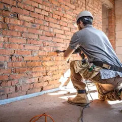 Budowlaniec wierci w ceglanej ścianie. Czy remont mieszkania można odliczyć od podatku?