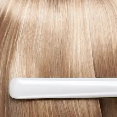 Plancha alisando cabello rubio. Soluciones para pelo quemado y dañado, recuperando su brillo y suavidad.