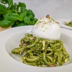 Makaron z kremowym pesto pistacjowym i burratą, posypany posiekanymi pistacjami. Pyszne danie, które zachwyci każdego miłośnika włoskich smaków.