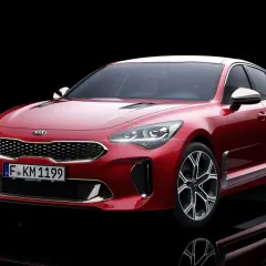 El potente motor del Kia Stinger, un sedán deportivo rojo brillante, se exhibe con su distintiva parrilla y faros LED.
