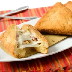 Mozzarella in carrozza in friggitrice ad aria: triangoli dorati e croccanti con cuore filante di mozzarella e prosciutto.
