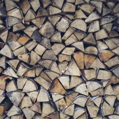 Stapel von gespaltenem Weidenholz, bereit als Brennholz für gemütliche Abende.