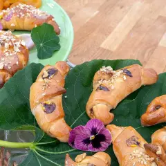Gyllene gifflar med nötter och torkad frukt, vackert arrangerade på gröna blad. Ett härligt recept på hembakade gifflar!