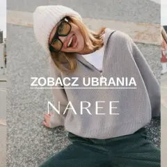 Kobieta w czapce i swetrze z wełny z merynosów, wesoło pozująca na tle ulicy.