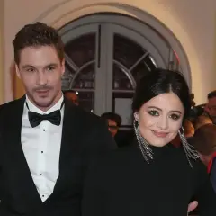 Adriana Kalska z partnerem na czerwonym dywanie, uśmiechnięci i eleganccy.