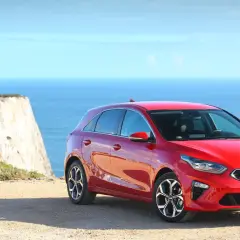 Czerwona Kia Ceed 1.4 benzyna na tle klifu i morza. Idealna na wakacyjne podróże.