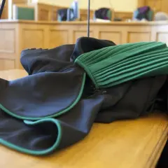 Toga adwokacka na stole w sali sądowej. Zastanawiasz się, ile zarabia adwokat z urzędu?
