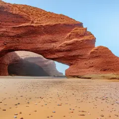 Piękne marokańskie plaże z czerwoną skalną bramą i kamienistym brzegiem.