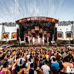 Folla in delirio al Decibel Open Air, con coriandoli e fumo che piovono dal palco. Un evento che celebra i migliori nomi dj techno.