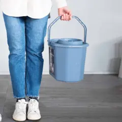 Persona con mocio e secchio pronto per lavare parquet.