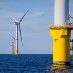 Wielkie turbiny wiatrowe na Bałtyku, symbolizujące **baltic power**, generują czystą energię na tle błękitnego nieba.