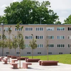 Nowoczesny budynek mieszkalny w stylu wuwa Wrocław z rzędami okien i zielenią.