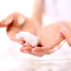 Zwei Hände halten eine kleine Menge eines selbstgemachten Peelings. Perfekt zum Handpeeling selber machen zum Verschenken.