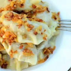 Pyszne pierogi z kaszą gryczaną i twarogiem, posypane chrupiącą cebulką. Idealne na obiad!