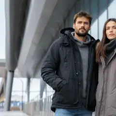 Para zimowych wyzwań: ona w szarej kurtce z futrzanym kapturem, on w czarnej. Idealna jaka kurtka na zimę dla pary.