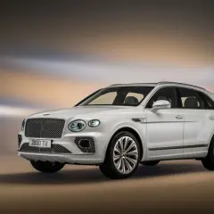 Elegancki, biały Bentley SUV z charakterystyczną kratą wlotu powietrza i stylowymi felgami, prezentujący luksus i moc.