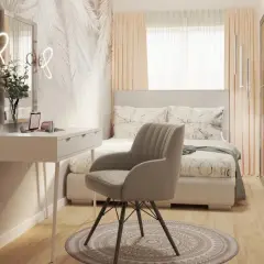 Przytulne łóżko w sypialni pod oknem, z toaletką i wygodnym fotelem.