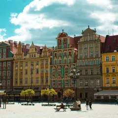 Kolorowe kamienice na wrocławskim Rynku, idealne na city break z Wrocławia. Słoneczny dzień, chmury na niebie.