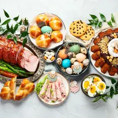 Wielkanocny stół pełen smakołyków: pieczona szynka, pascha, jajka, babki, ciasteczka i inne pyszności. Idealne co do jedzenia na wielkanoc.