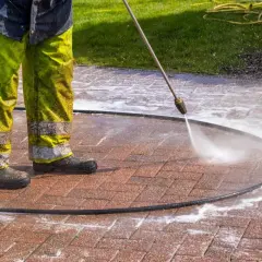 Czyszczenie kostki brukowej myjką ciśnieniową. Woda pod ciśnieniem skutecznie usuwa plamy, pokazując, czym zmyć olej z kostki.