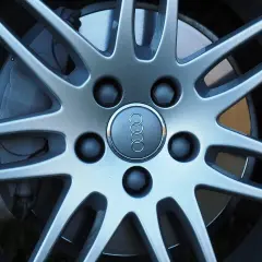 Zbliżenie na felgę Audi z widocznymi śrubami. Dowiedz się, jak zmierzyć rozstaw śrub, by dobrać odpowiednie felgi.