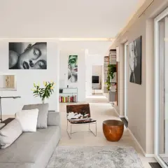 Ein heller Wohnraum mit Kunstwerken, wie sieht die Farbe Beige aus, die Wände und der Boden sind in diesem warmen Ton gehalten.