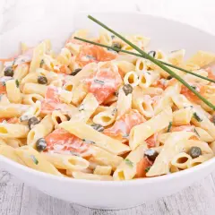 Pâtes crémeuses avec saumon fumé, câpres et fines herbes. Un délice de pâtes saumon épinard, garni de ciboulette fraîche.