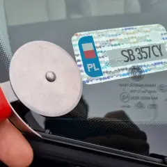 Narzędzie do usuwania naklejek z szyby, obok widoczna polska knt rejestracja SB 357CY.