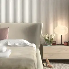 Elegancka sypialnia z łóżkiem, na którym leżą białe ręczniki i różowa poduszka. Ściana za łóżkiem ozdobiona jest pionowymi **lamele w sypialni**.
