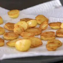 Patatas al horno recién hechas, doradas y crujientes, reposando sobre papel absorbente. ¡Listas para disfrutar!