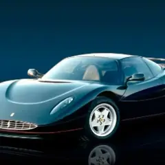 Czarny, sportowy samochód Ferrari z lat 90. z charakterystycznym grillem i opływową sylwetką. To rzadki model, który zapowiadał przyszłe LaFerrari.
