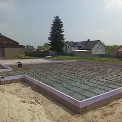 Fundament pod dom w Niemczech, gotowy do zalania betonem. Praca na budowlance trwa.