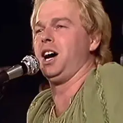 Wokalista Budki Suflera, Robert Gawliński, śpiewa do mikrofonu.