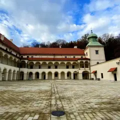 Dziedziniec zamku Sucha Beskidzka z arkadowymi krużgankami i wieżą.
