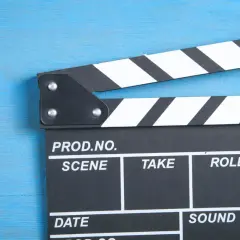 Klapka filmowa na niebieskim tle. Czy zastanawiałeś się, ile zarabia polski aktor?
